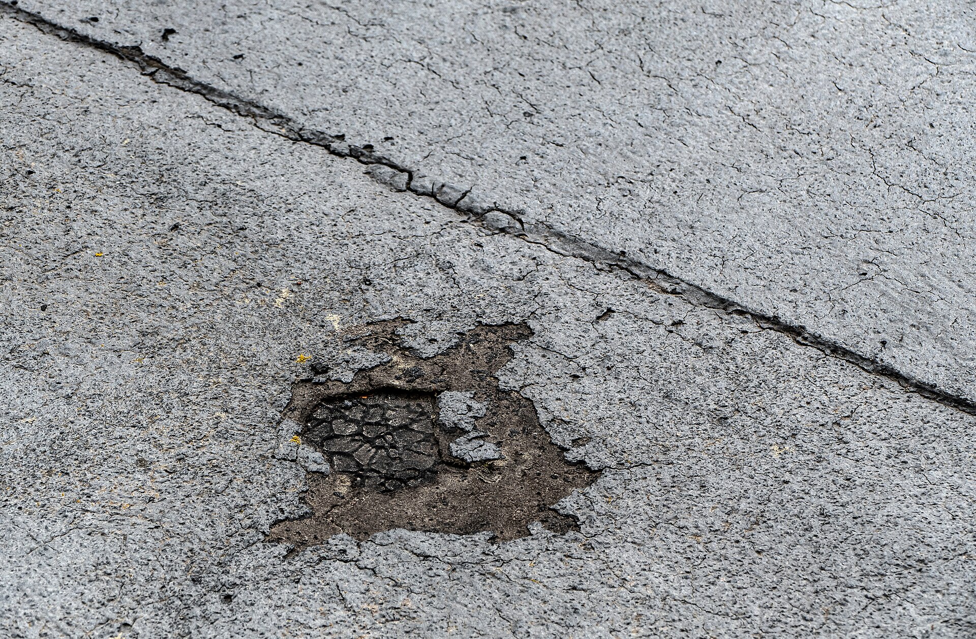 Close view of a cracked and failing low-slope roof surface